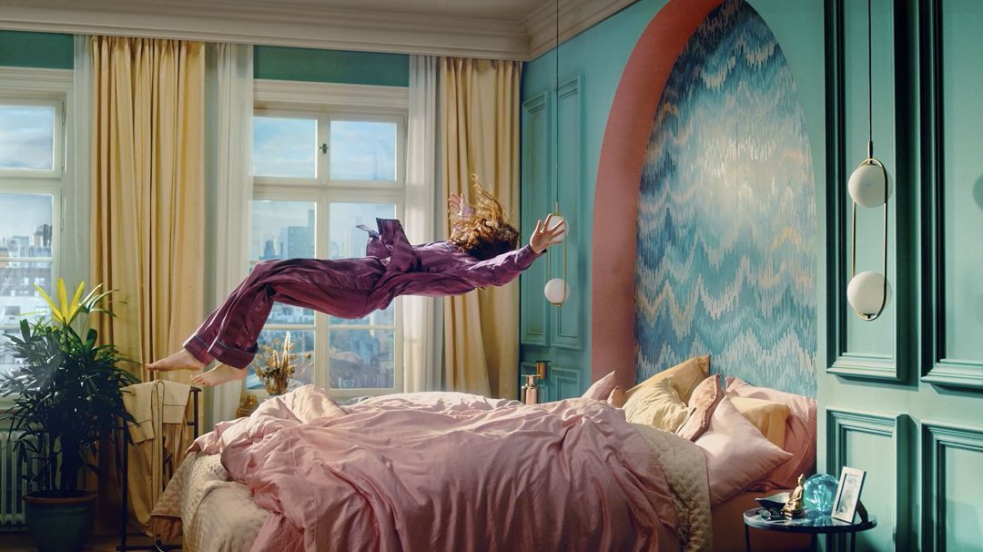 Човек падащ върху легло